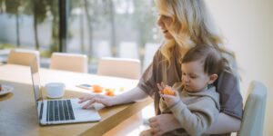 A digital nomad parent working in a sunlit home office.