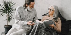 An elderly person sharing stories with their adult child in a comfortable home environment, symbolizing the preservation of family history.