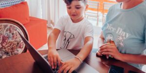 A parent and child planning a local trip together using a map and tablet.