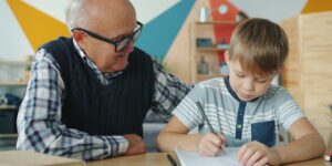 An older adult and an adult child sitting together preparing to record a family history interview.