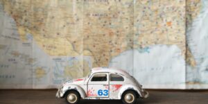 A travel planning map on a table with a toy car indicating a local destination.