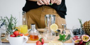 A stylish home mixology station with fresh ingredients and glassware for a non-alcoholic cocktail workshop.