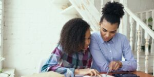Parent and teen exploring family history together using digital and physical archives.