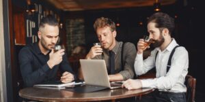 Professionals networking with non-alcoholic drinks in a bright cafe.