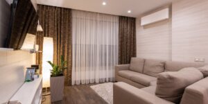A modern, clean living room featuring a smart home air quality monitoring device.