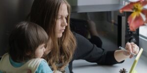 Parent and toddler peacefully engaging with a tablet together in a cozy living room.
