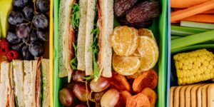 A balanced and healthy school lunchbox featuring diverse, international snack components.