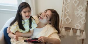 Parent and child looking at a tablet together in a bright living room