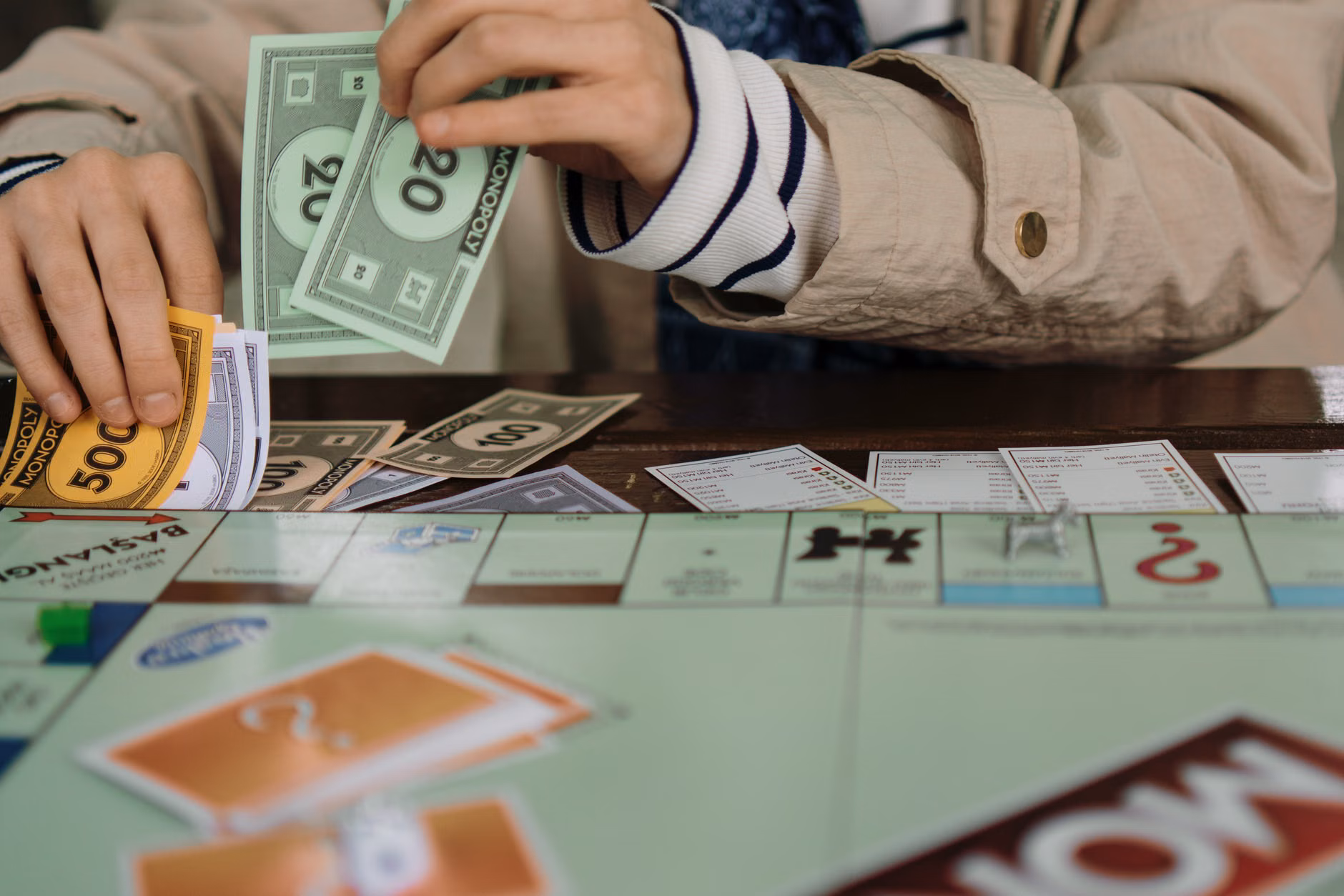 Child moving play money tokens on a game board.
