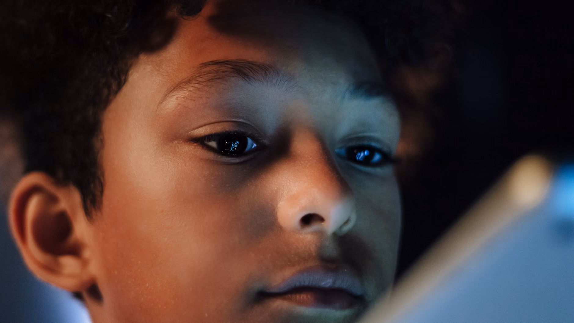 Close-up of a child using a tablet to learn critical thinking.