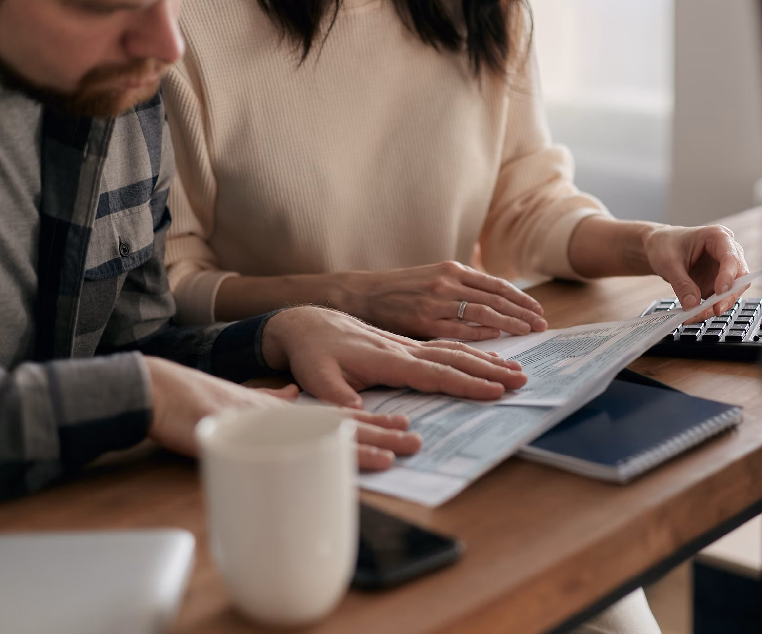A couple in their 30s reviewing financial documents together
