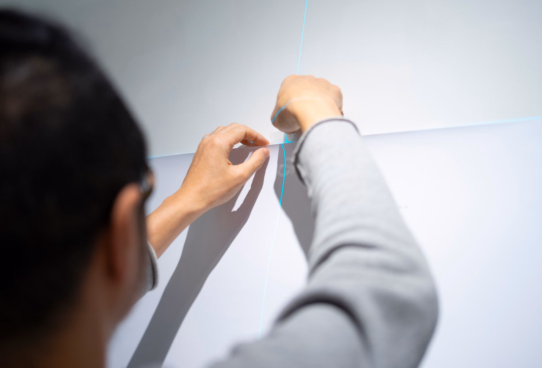 Close-up of a person adjusting a modular bookshelf system.