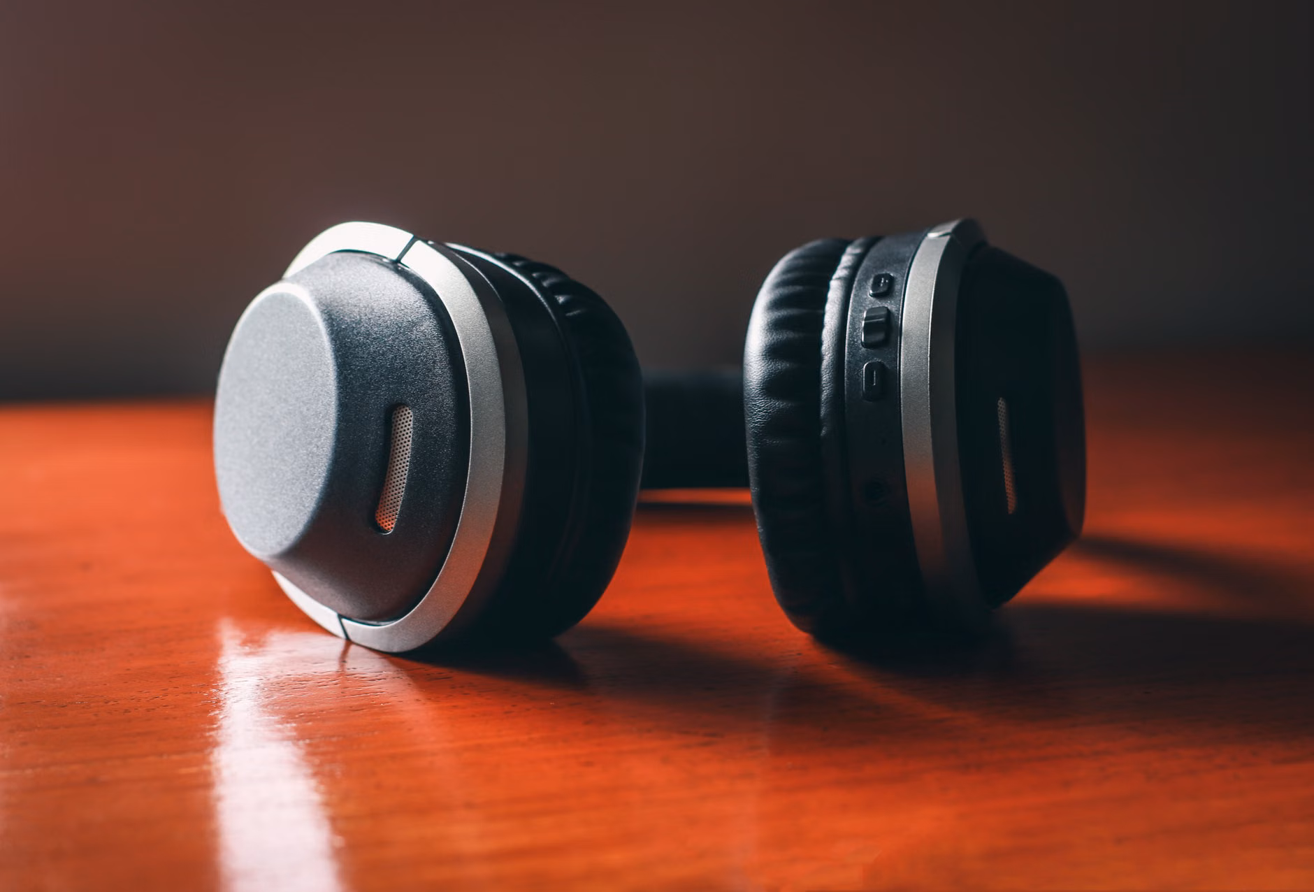 Noise-canceling headphones on a hotel nightstand for sleep optimization.