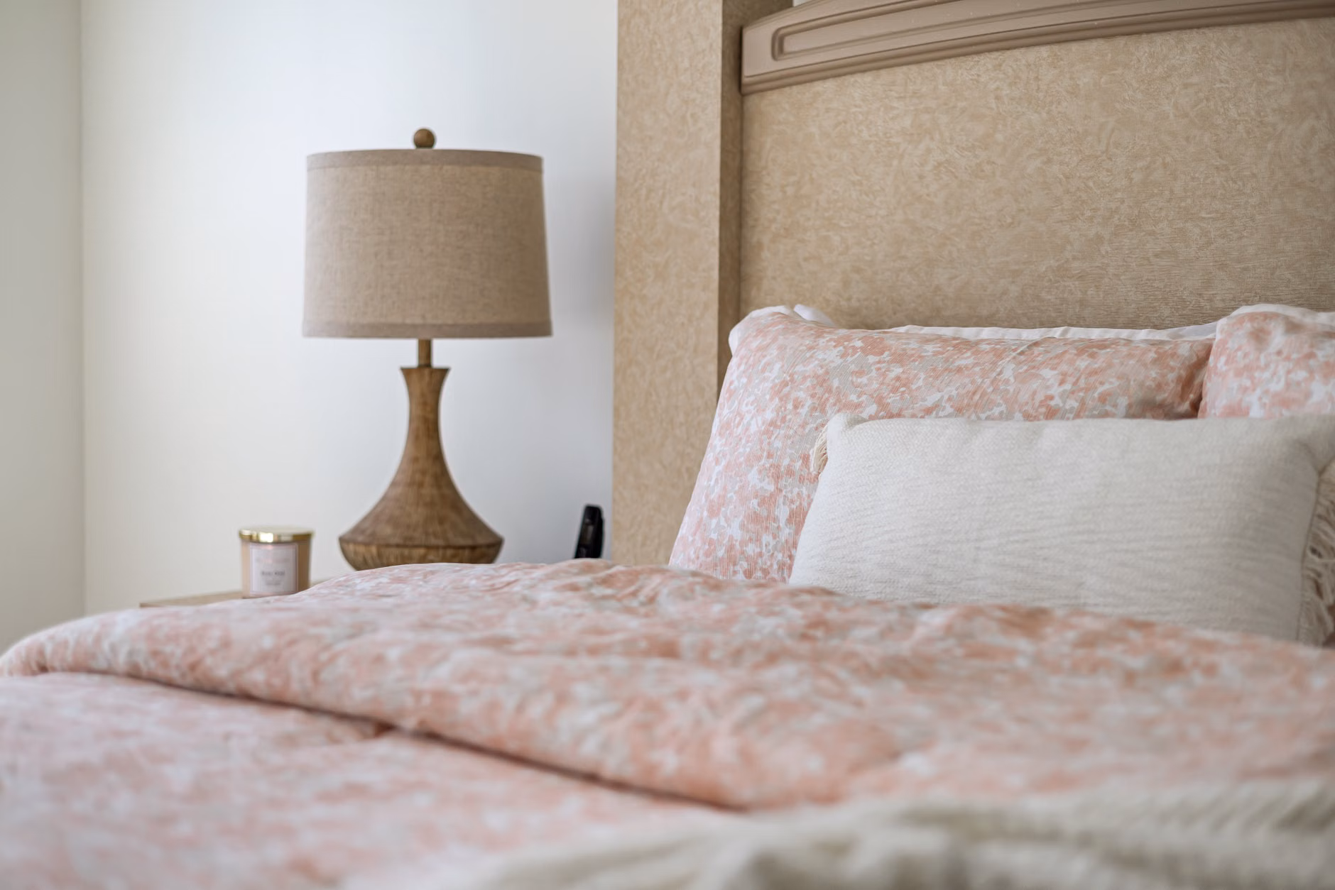 A cozy bed with weighted bedding and neutral-colored linens, designed for sensory comfort.