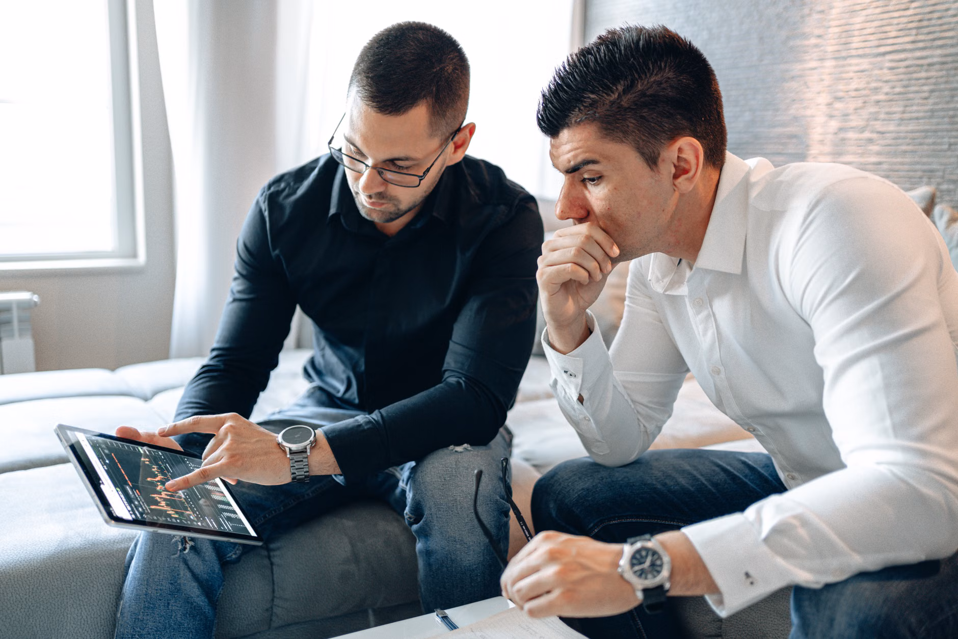 Two adults reviewing digital security settings on their devices in a kitchen.