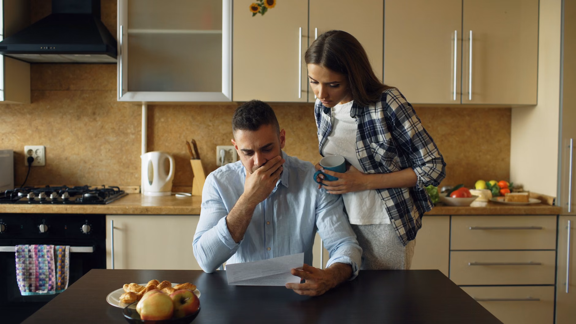 A family organizing household appliance documents and manuals at a kitchen table.