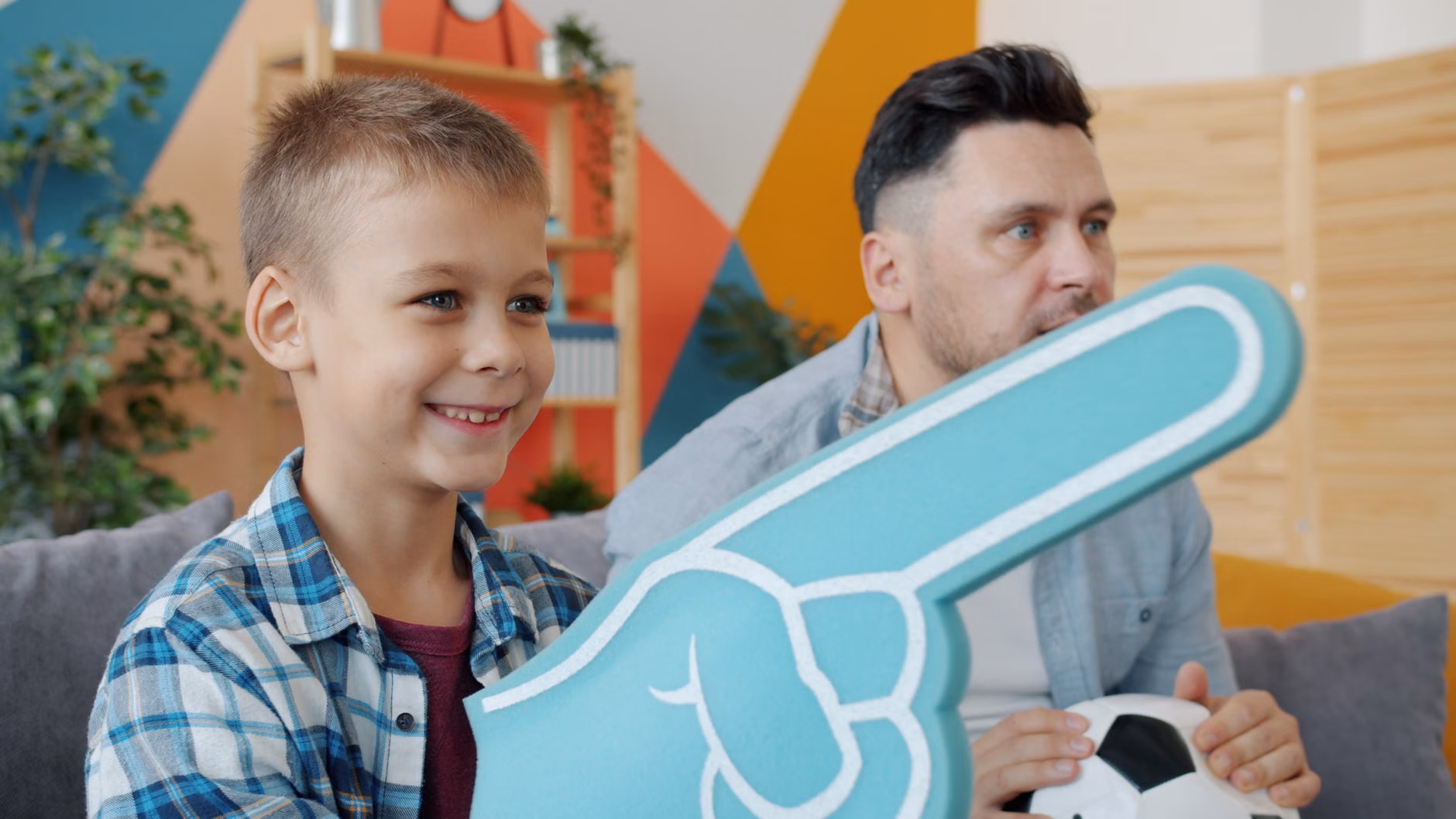 Parent using a handheld emotion fan to communicate with a toddler at eye level.