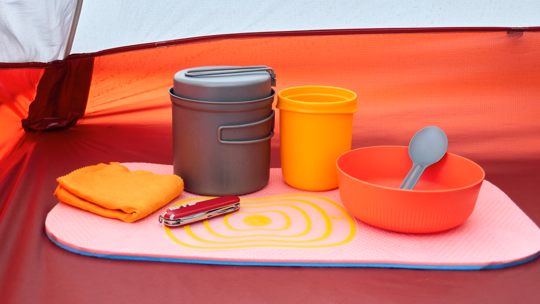 A practical and organized camp kitchen setup on a beach.