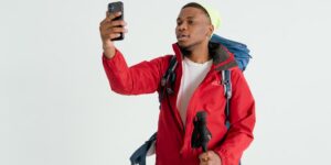A hiker checking a smartphone for navigation on a remote mountain trail.