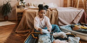 An organized suitcase packed for a winter family trip with essentials neatly arranged.
