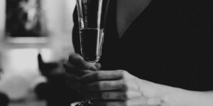 A sophisticated dinner party featuring elegant non-alcoholic drinks and a blurred social gathering in the background.