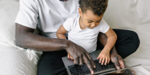 A parent and toddler engaging with a screen together in a cozy living room.