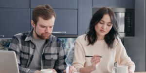 A family collaborating on a home project at a kitchen table.