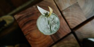 A sophisticated zero-proof cocktail on a wooden table in soft sunlight.