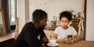 A parent and child discussing emotions using a digital tool at home.