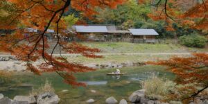 A serene autumn river scene with a canoe, perfect for a slow-adventure travel guide.