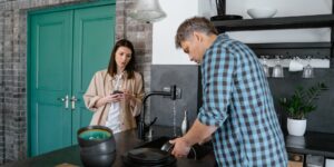 A couple organizing household tasks together in a modern kitchen.