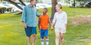 A group of parents walking and talking together in a park, symbolizing a social-wellness community.