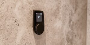 Modern smart thermostat installed on a wall in a bright, minimalist home.