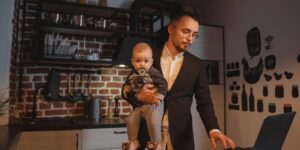 A young couple balancing work and parenting in a modern home setting.