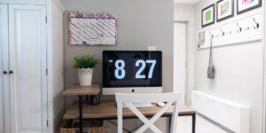A modern, organized desk setup featuring a digital family calendar on a tablet.