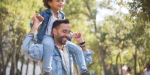 A father and son walking together in a park, representing the bond of fatherhood.