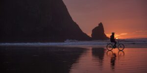 A cyclist enjoying a peaceful coastal ride at sunset.