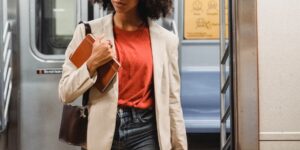 A professional woman in her 30s holding a luxury handbag in a home office.