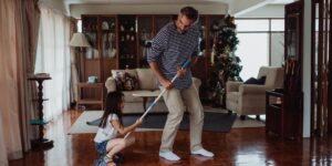 A happy family working together on household chores in a bright living room.