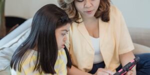 A parent and child exploring family history on a tablet together.