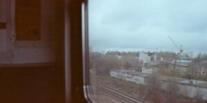 A scenic view from a train carriage window overlooking a beautiful coastline.