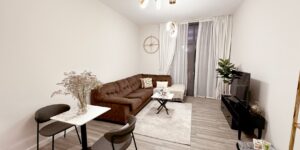 A couple reconfiguring a modular sofa in a bright, modern living room.
