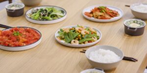 A spread of deconstructed, healthy ingredients on a dining table for family meal prep.