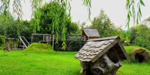 A scenic urban nature-play area featuring wooden structures and greenery.