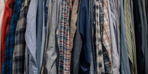 A rack of organized, gently used school uniforms hanging in a sunlit room.