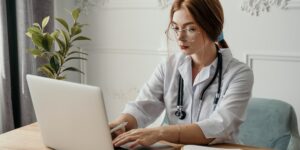 Digital and physical organization of family medical records on a home office desk.