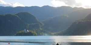 A serene lake at sunrise with a kayak, representing the calm of slow-adventure water sports.