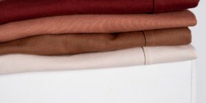 A minimalist, organized wardrobe of gender-neutral toddler clothing in earth tones.