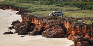 A family camping on a scenic, rugged coastline during sunset.