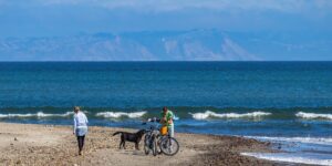 A family enjoying a scenic bicycle ride on a coastal path during sunset.